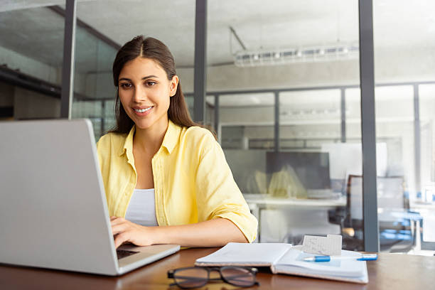 istock Smiling latin hispanic female marketing manager, professional it specialist working, browsing at laptop computer sitting at desk in modern office. Cheerful young woman employee using pc for business 2208637360