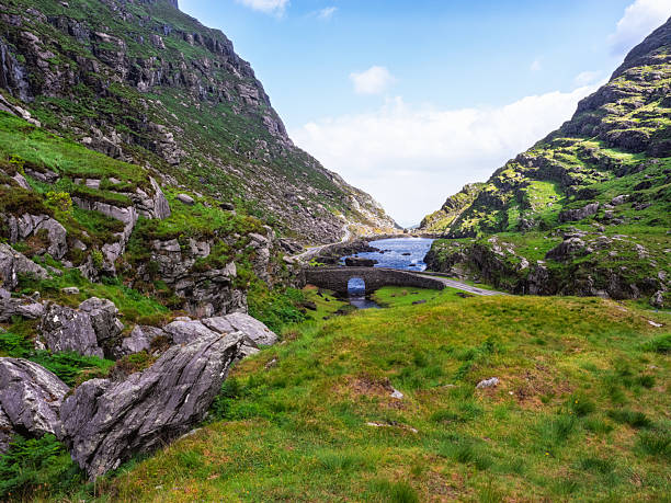istock Wishing Bridge stands majestically over a serene river, framed by dramatic cliffs and vibrant green hills. Visitors can enjoy the tranquil landscape and beautiful nature in this Irish wonder. 2208638018
