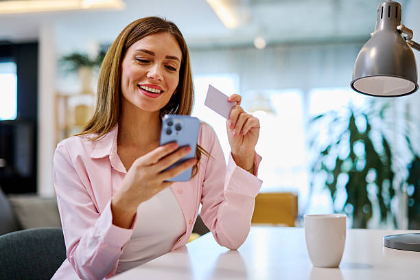 istock Young Woman Making Online Payment Using Smartphone and Credit Card at Home 2208639366
