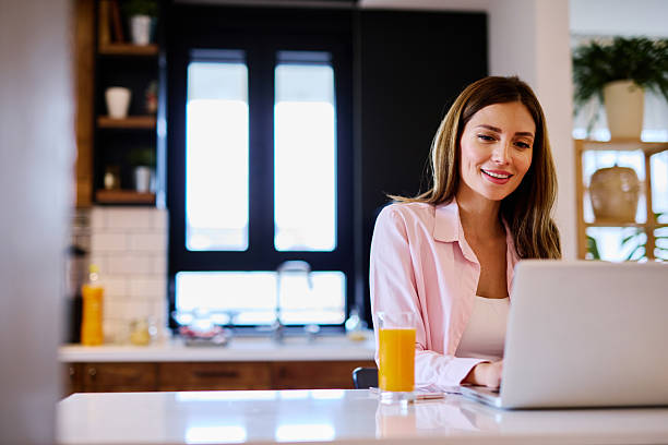 istock Young Woman Working From Home on Laptop in Kitchen 2208639385