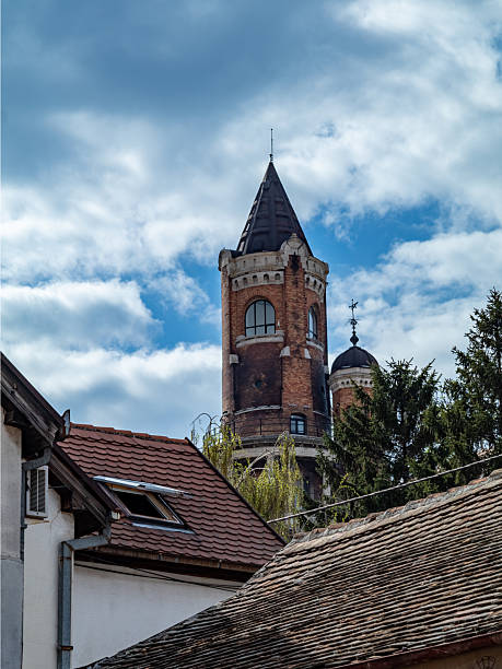 istock Historic Brick Tower Rising Above Rooftops Under Blue Skies 2208640440