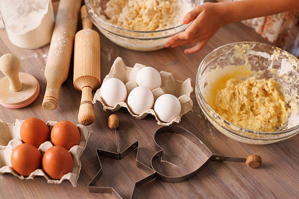 istock Kids mixing dough with whisks among eggs, tools, and flour on a rustic kitchen table. 2208653979