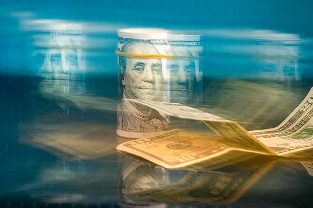 istock Benjamin Franklin portrait on a 100 dollar roll with different American money 2208655493