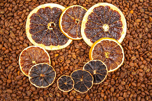 An enticing macro shot of dried citrus slices paired with dark coffee beans, highlighting their contrasting textures and earthy tones. coffee aroma and taste descriptors