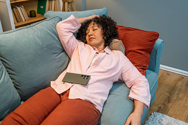 istock Tired woman taking a nap on the sofa 2208665694
