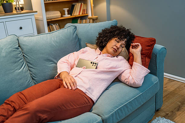istock Exhausted woman falling asleep on the couch 2208665868