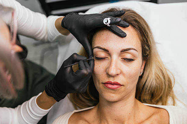 istock Beautician applying permanent eyeliner makeup on client's eyelid 2208668503