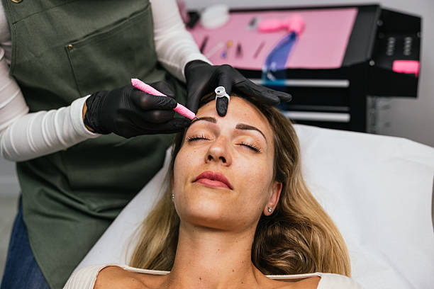 istock Beautician applying microblading treatment on eyebrows of client 2208669784
