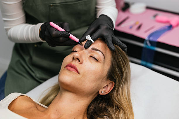 istock Beautician applying microblading treatment on eyebrows of client 2208669886