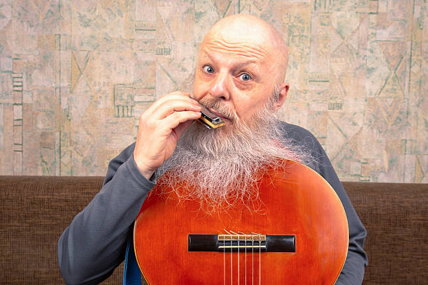 bearded man with a harmonica in his hand. music and hobbies