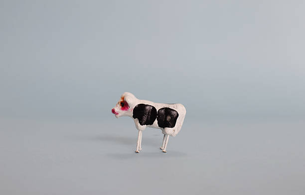 istock Small decoration cow figurine.  Isolated on light blue background. 2208673618