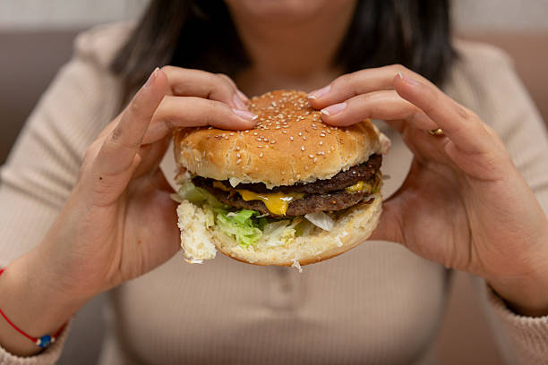 istock Woman eating beef burger 2208674100