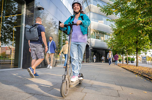 istock Woman Riding Her E-scooter On Sidewalk In City 2208676194