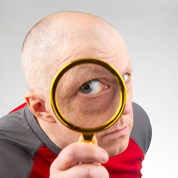 istock man looks through a magnifying glass 2208679741