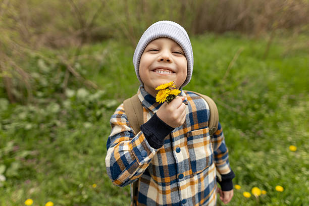 Four year old kid playing in park and on the playground on sunny springtime afternoon