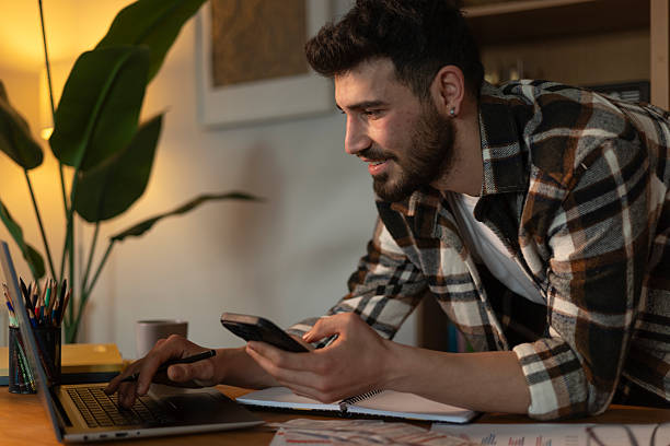 istock Young man working from home, using laptop and smartphone 2208681170