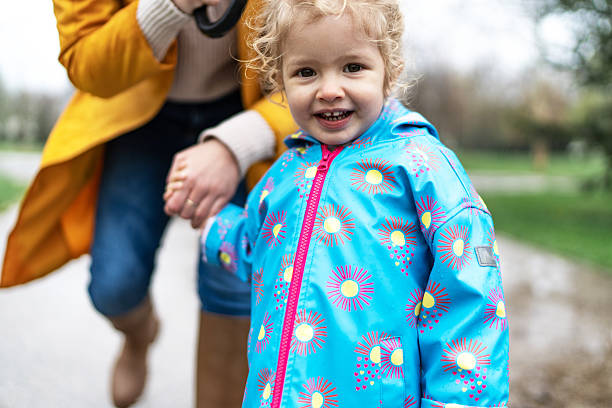 istock Happy toddler in colorful raincoat smiling at camera 2208681392