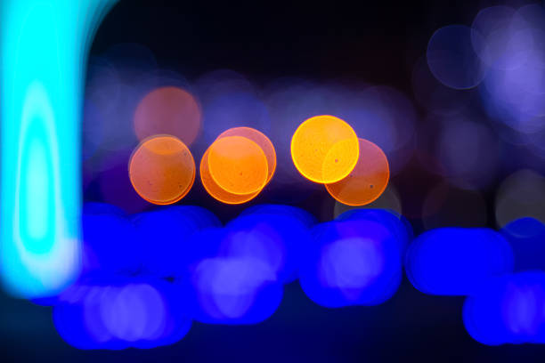 Blurred golden and colorful bokeh lights on a dark surface, evoking a festive or whimsical mood with a warm, out-of-focus aesthetic