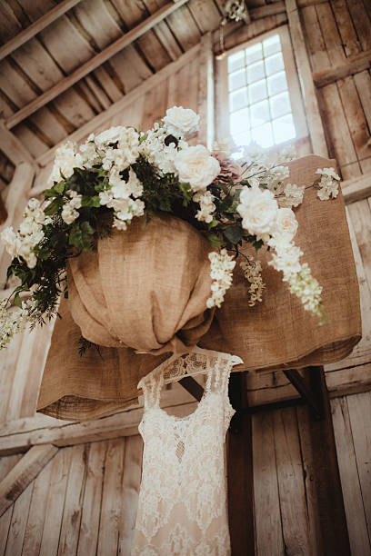Lace wedding dress hanging up in barn Close up of lace wedding dress hanging up in light colored barn hoops wedding stock pictures, royalty-free photos & images