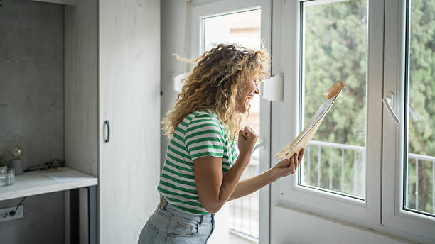 istock caucasian woman open mail letter or document envelope at home 2208683094