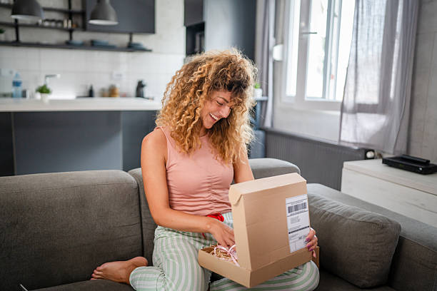 istock one happy woman open mail cardboard package box present at home 2208683943