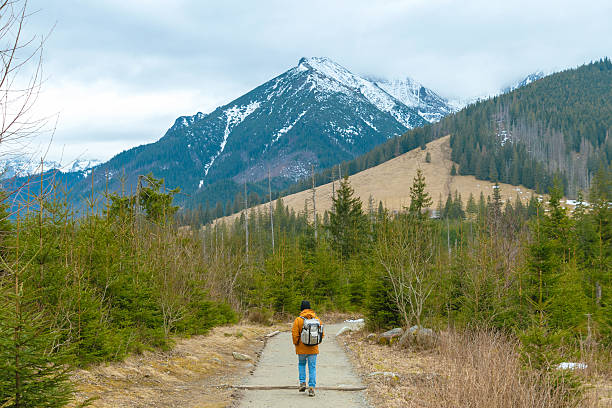 istock A man walks along a mountain path. Hiking in the mountains in early spring. 2208685370