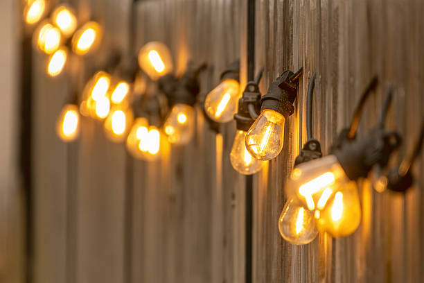 istock Warm string lights glow softly against a wooden wall, creating a cozy and inviting ambiance 2208685454