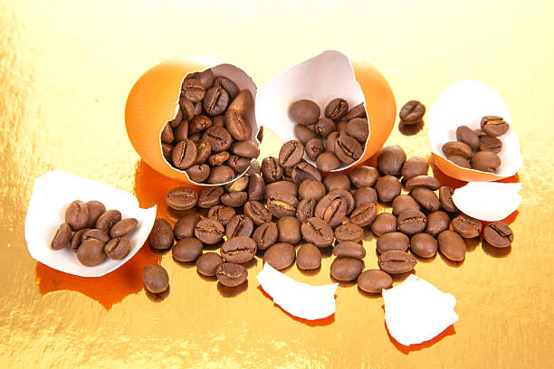 istock A cracked orange egg spills coffee beans onto a reflective gold surface, surrounded by broken shells, creating a surreal blend of nature and aroma in a striking composition 2208686257