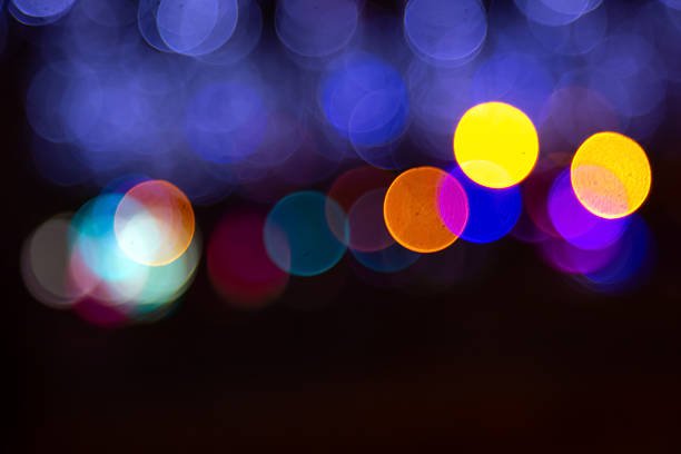 Dreamy bokeh with golden and vibrant light spots on a dark setting, suggesting a festive or romantic ambiance with a blurred, artistic touch.
