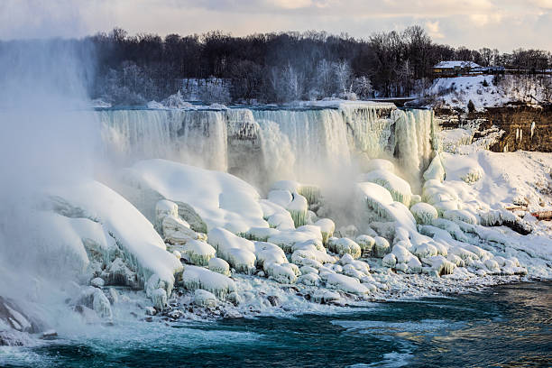 A breathtaking view of Niagara Falls enveloped in frost and snow during winter, showcasing nature's awe-inspiring power and serene beauty.