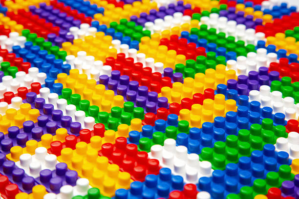Abstract background texture of colored constructor blocks. Background of colorful plastic part of constructor. Pile of colored toy bricks.