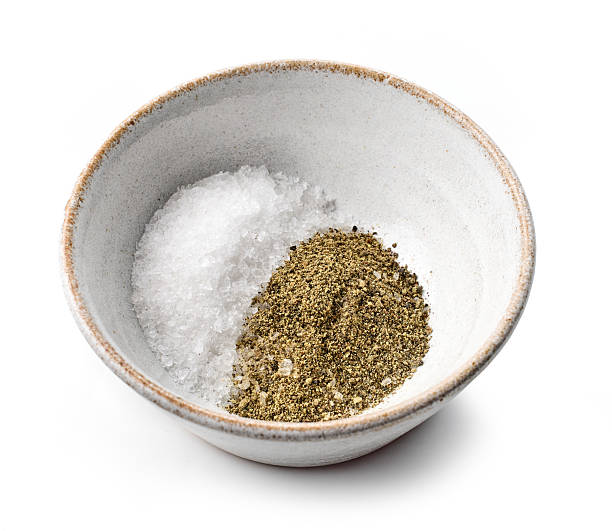 bowl of salt and pepper isolated on white background, top view