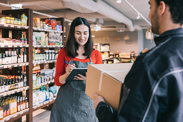 istock A courier holds a box while the worker finalizes the delivery with her signature 2208690955
