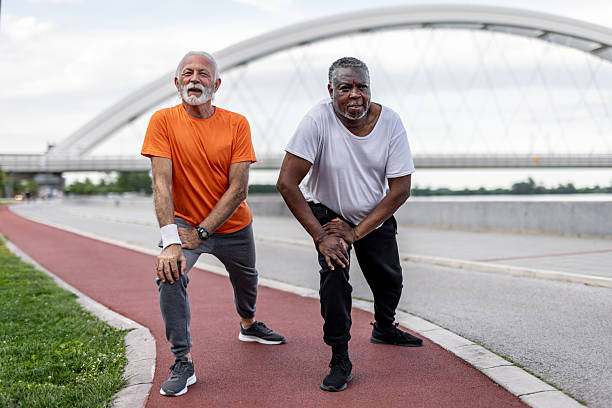 istock Two senior men stretching legs before running in a city park 2208692351