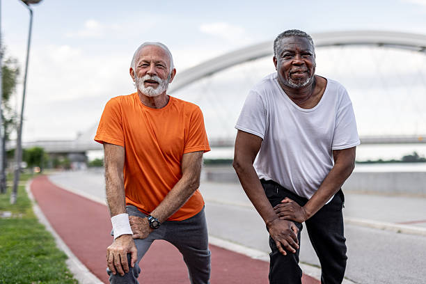 istock Two senior men stretching legs before running in a city park 2208692356