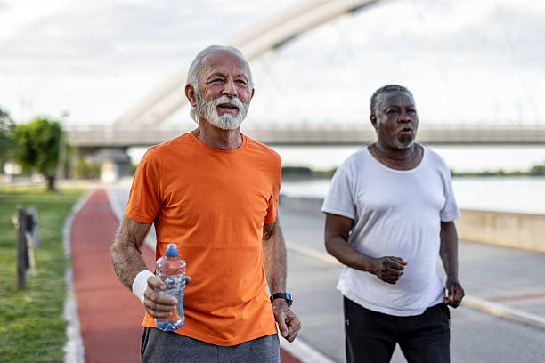 istock Two senior men jogging outdoors in a park 2208692532
