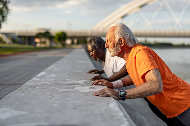 istock Two senior men doing push-ups outdoors by the river 2208692609