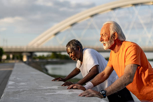 istock Two senior men doing push-ups outdoors in urban setting 2208692612