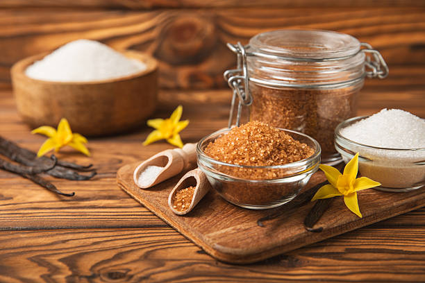 Aromatic vanilla sugar. Vanilla pods. Vanilla sticks, brown and white sugar in a bowl on a textured background. Vanilla flowers, spices and herbs for desserts and baking. Space for text. Copy space