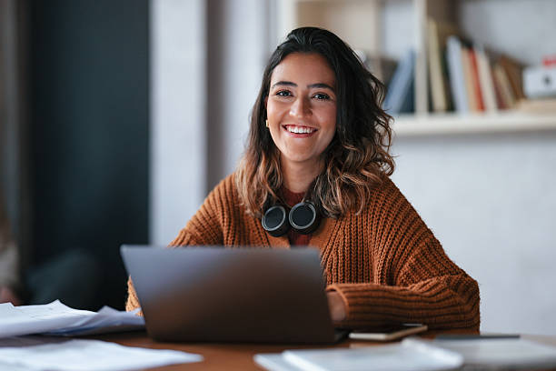 istock Smiling Student Working on Laptop in Cozy Library Environment 2208695100