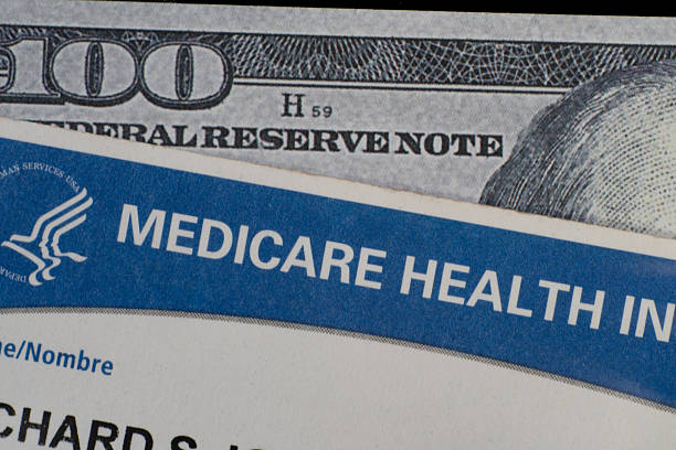 Close up of Medicare card on 100 USD note.