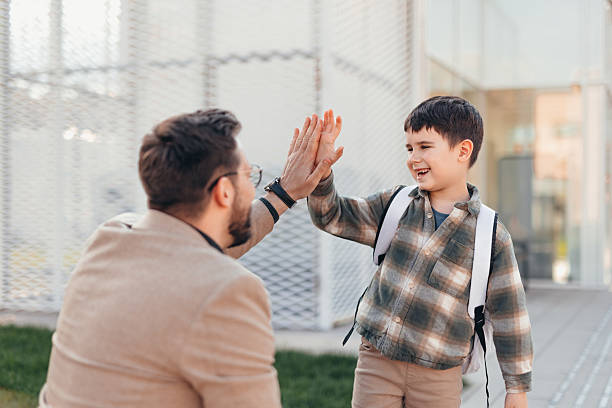 istock Father and son giving high five in front of school 2208700122