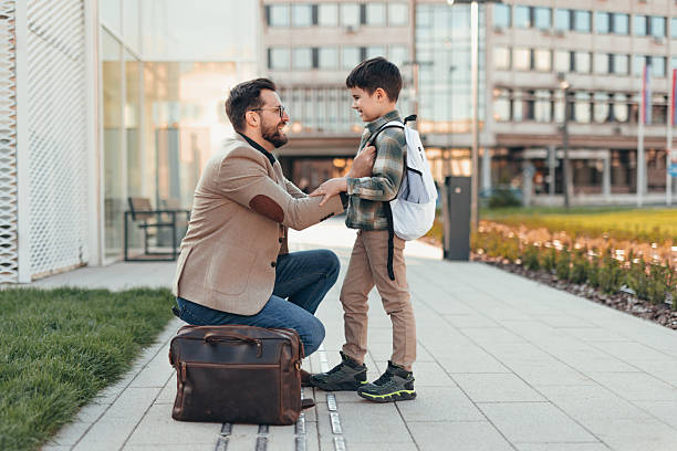 istock Father Kneeling and Encouraging his Son Before School 2208700130