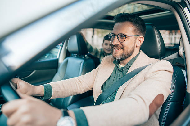 istock Father driving car with his son in the back seat 2208700190