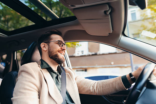 Young businessman driving his car and smiling