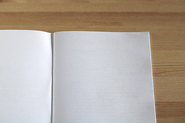 istock Open book lying on wooden table shows blank pages 2208702643