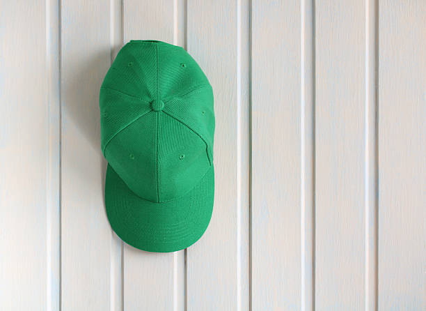istock Green baseball cap hanging on white wooden wall 2208704426