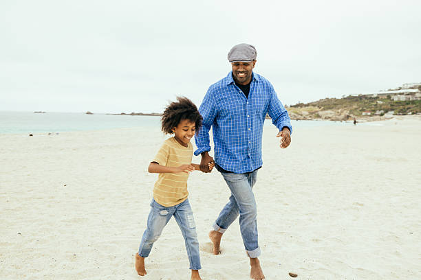 Father giving son piggyback ride on beach