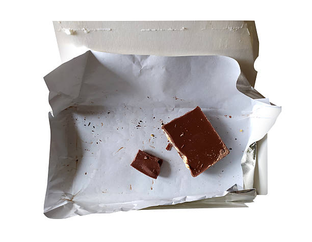 Almost gone chocolate bar. Top view of opened wrapper with last pieces. Perfect for illustrating temptation, indulgence, or dietary themes. Lifestyle concepts.