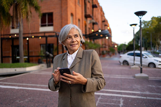 istock Professional Woman in Business Suit Using Smartphone Outdoors at an Urban District 2208726014